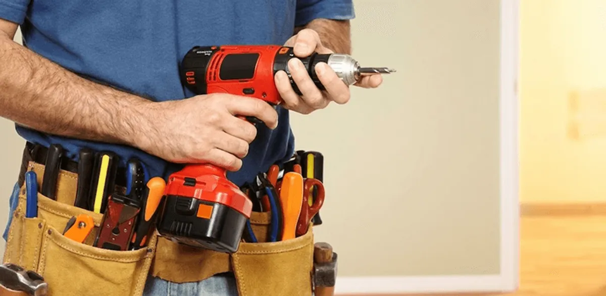 Handyman holding a power drill for home repairs and installations in West Palm Beach, FL